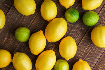 Scattered lemons with limes on a wooden background. flat lay.