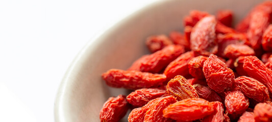 白バックと右側に白いお皿とクコの実　左側にコピースペース