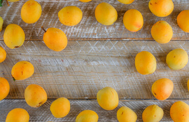 Tasty apricots on wooden background, flat lay.