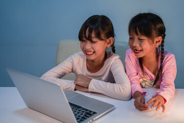 Two girls watch cartoons on her laptop as her favorite.