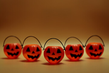 Halloween pumpkins with painted face on color background