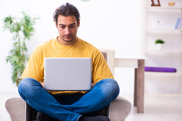 Young handsome man with computer at home