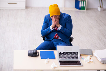 Sick male employee suffering at workplace from coronavirus