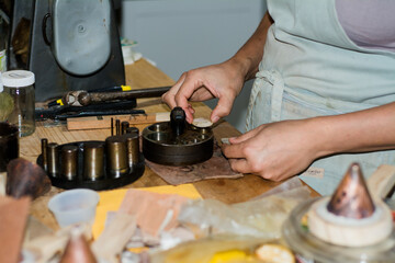 Jewelry maker woman working in professional jewelry workshop at her workbench.
