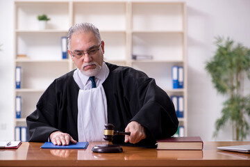 Old male judge working in courthouse