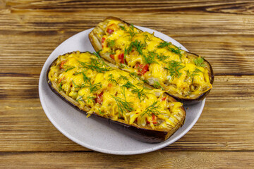 Baked stuffed eggplants on a wooden table. Healthy food and dieting concept