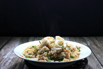 Fried and stirred noodle with sliced squid, fresh peeled shrimp, chicken, egg, Chinese kale and spring onion on the plate. Famous traditional noodle menu in Asia restaurant. 