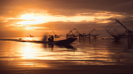 Fototapeta na wymiar scenery of sunrise over lake with thai traditional fishing trap at Pakpra