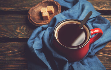 Natural black coffee in a red mug on wooden background