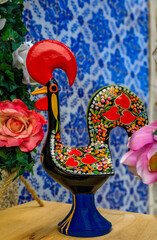 Porto, Portugal - May 29, 2018: Traditional Portuguese Barcelos Rooster or Galo de Barcelos symbol of Portugal with azulejo tiles in the background