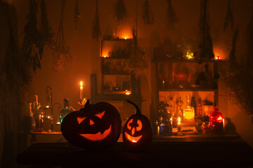 Halloween pumpkins with candles and magic potions at night indoor