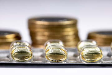 Macro shot pile of tablets pill in silver aluminium blister packaging with money coins background in Brazil
