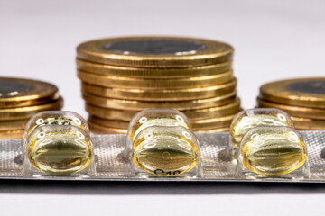 Macro shot pile of tablets pill in silver aluminium blister packaging with money coins background in Brazil