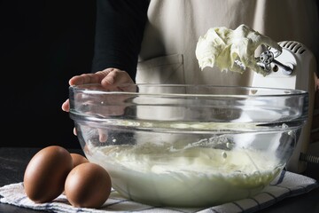 Lady making cream cake bakery over black background