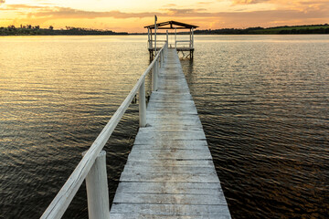 pier on the edge of a lake with sunset background in Brazil