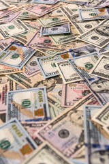 Dollar banknotes dispersed on wooden table close up