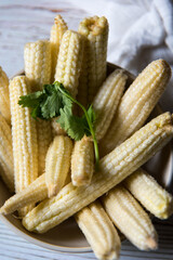 Close up of fresh baby corns in a heap with use of selective focus.