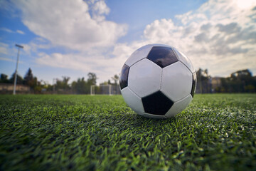 Black and White Soccer Ball On Stadium Lawn On Blue Sky Background                      