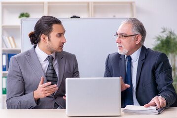 Obraz premium Old and young businessmen in business meeting concept