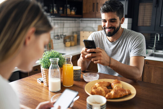Couple having fun using their mobiles