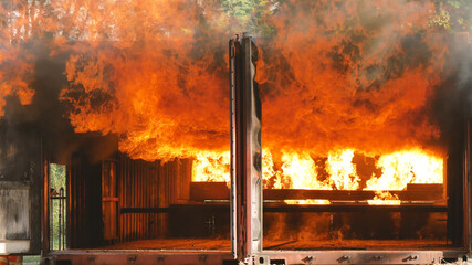 Firefighter fighting with flame using fire hose chemical water foam spray engine. Fireman wear hard...