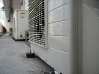 closeup of air conditioner compressor outside building.