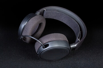 Fototapeta na wymiar Black headset with full size headphones on a dark background
