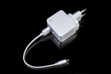 Mobile devices charger with connected USB cable on dark background