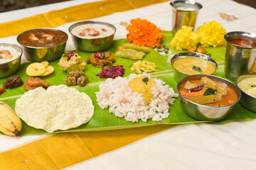 Traditional Onam sadhya, boiled rice, served for Kerala Indian festival  with curries Sambar, Rasam, Pulisseri, Avial, Thoran, Papadum, Payasam, Banana, Yogurt or Buttermilk, chips