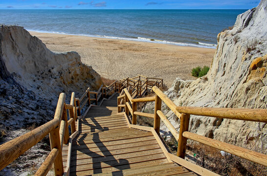 Rustic wooden stairs leading down the Asperillo cliff, natural monument on Castilla beach (Cuesta Maneli), Huelva, southern Spain, Europe