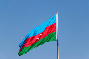 Azerbaijan Flag against blue sky. National flag of Azerbaijan on strong wind in the sunny day