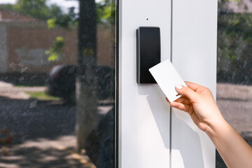Woman using card to open door outdoors