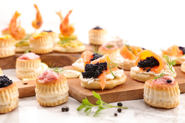 festive canape, buffet food- puff pastry with caviar, salmon and seafood cream