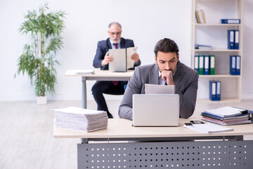 Old boss and his young assistant working in the office