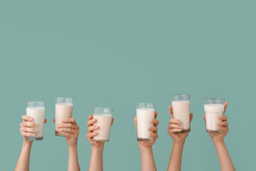 Female hands with glasses of vegan milk on color background - obrazy, fototapety, plakaty