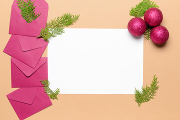 Beautiful Christmas decorations with empty card and envelopes on color background