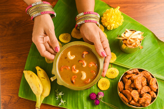 Onam sadhya sweet parippu payasam or dal kheer dessert Kerala, South India. Indian mithai. Women hand serving delicious festival sweet dish for Onam, Vishu, Deepawali, sweet food 