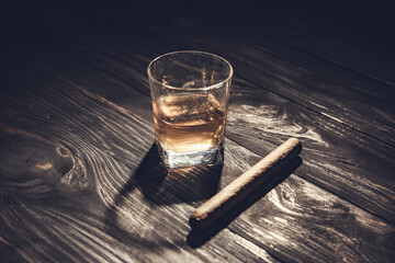Whiskey and cigar on wooden background close up