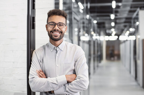 Handsome young businessman with folded arms in the office, Cheerful self confident men with crossed hands portrait, Business success concept