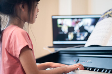Homeschool Asian young girl learning piano from music online class. © Kawee