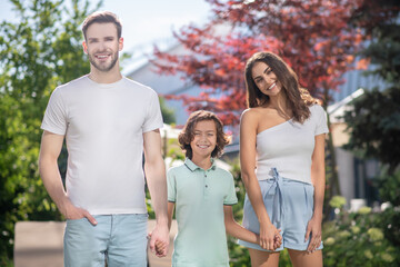 Obraz premium Dad mom and son walking holding hands in nature