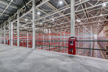 Large warehouse. Tall and long metal shelving.