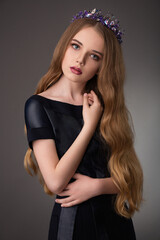 Naklejka premium beautiful teen blonde girl with exquisite makeup in a stylish black dress