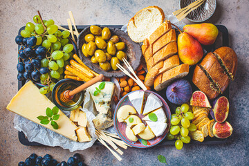 Cheese plate served with fruits, honey and snacks, top view. Assorted cheese background.