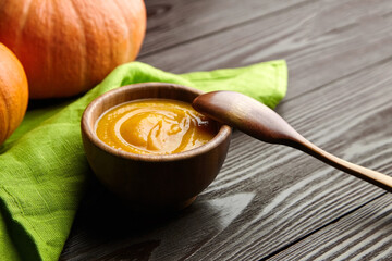 Autumn pumpkin cream soup in wooden bowl