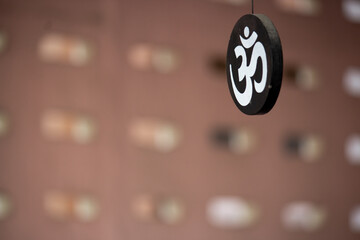 Hindu symbol Om painted white hanging on a circular piece of wood painted black in a house