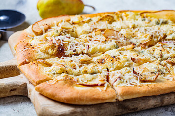 Homemade pizza with pear and gorgonzola, gray background.