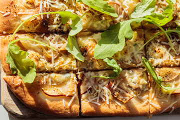 Homemade pizza with pear,  arugula and cheese, gray background.