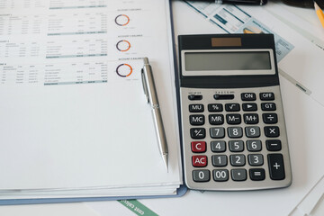 The calculator, pen and document on the table.