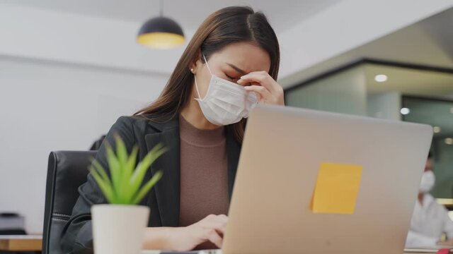 Asian young businesswoman is working on computer has headache sickness